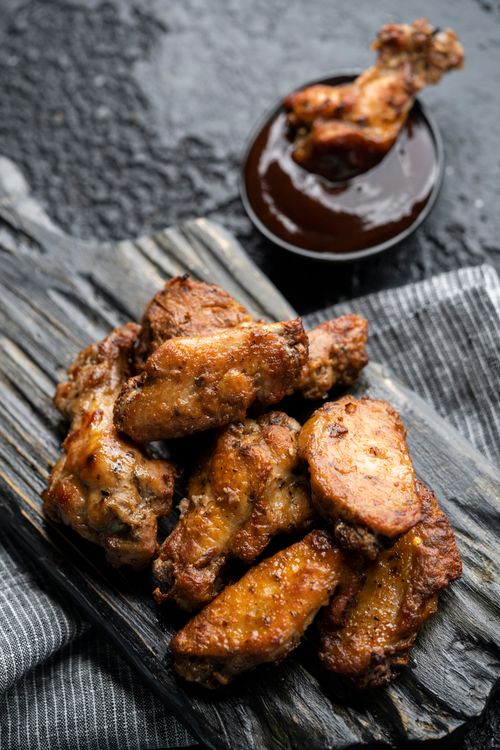 Free Appetizing barbecue chicken wings served with rich dipping sauce on rustic wooden board. Stock Photo