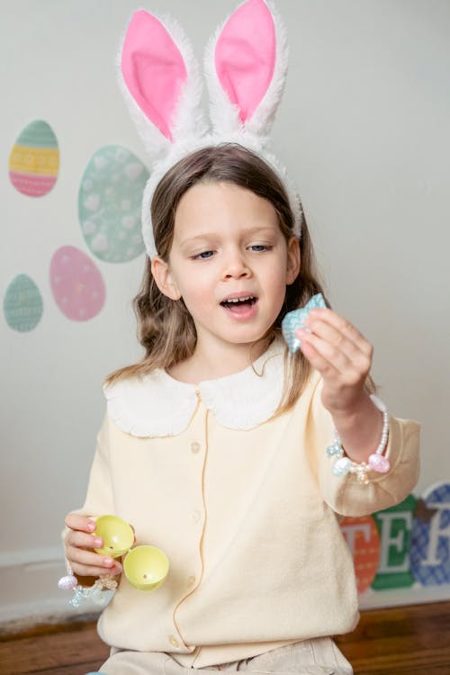 Surprised girl with bunny ears with decorative egg and paper