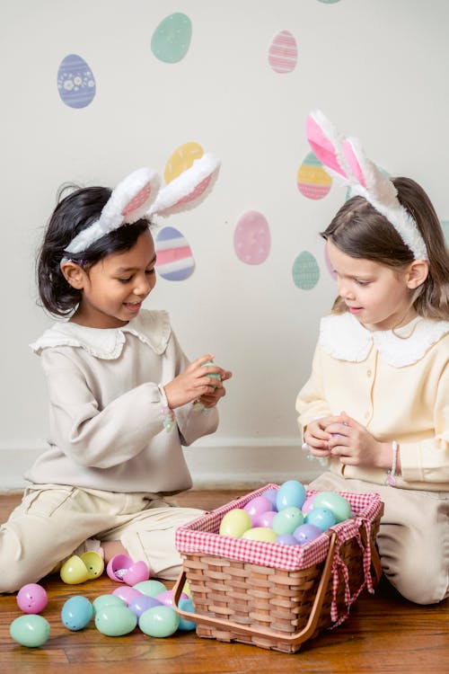 Free Charming diverse girls with decorative Easter eggs at home Stock Photo