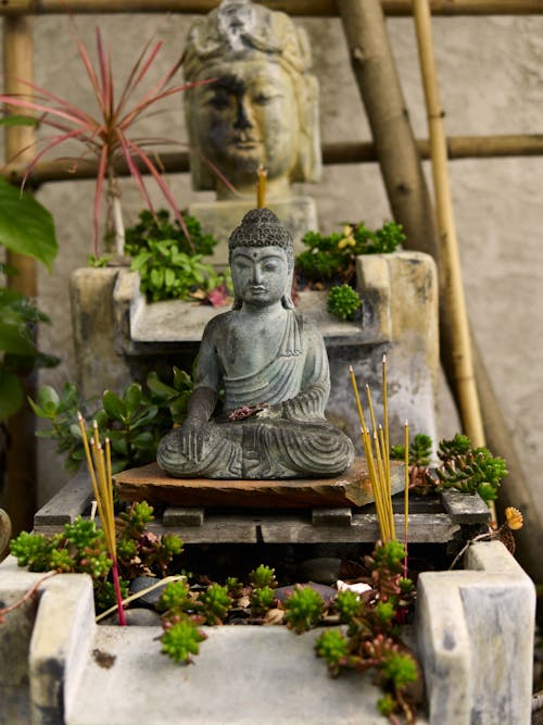 Free Gray Buddha Statue on Brown Wooden Bench Stock Photo