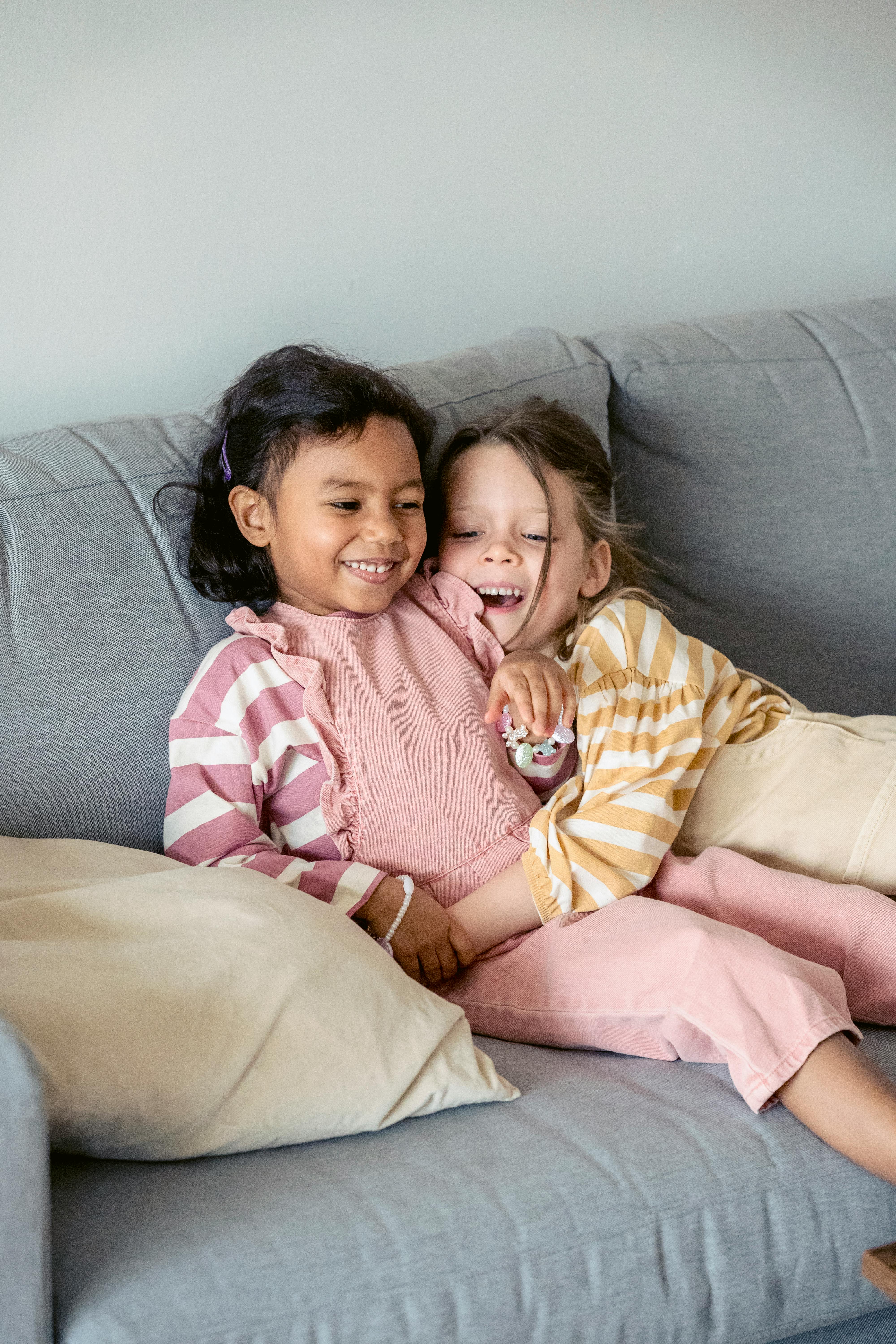 content girl embracing hispanic friend on couch at home