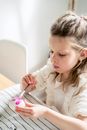 Gentle girl painting egg on Easter Day at home