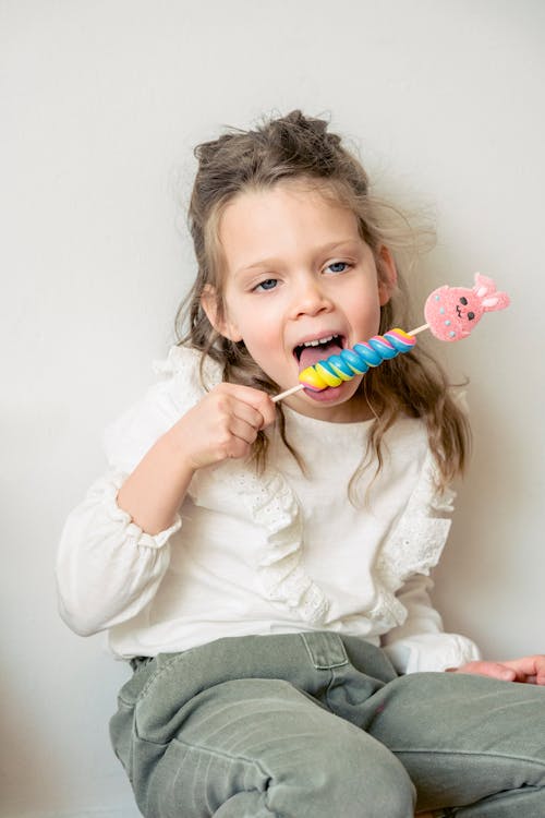 Cute little girl eating multicolored candy