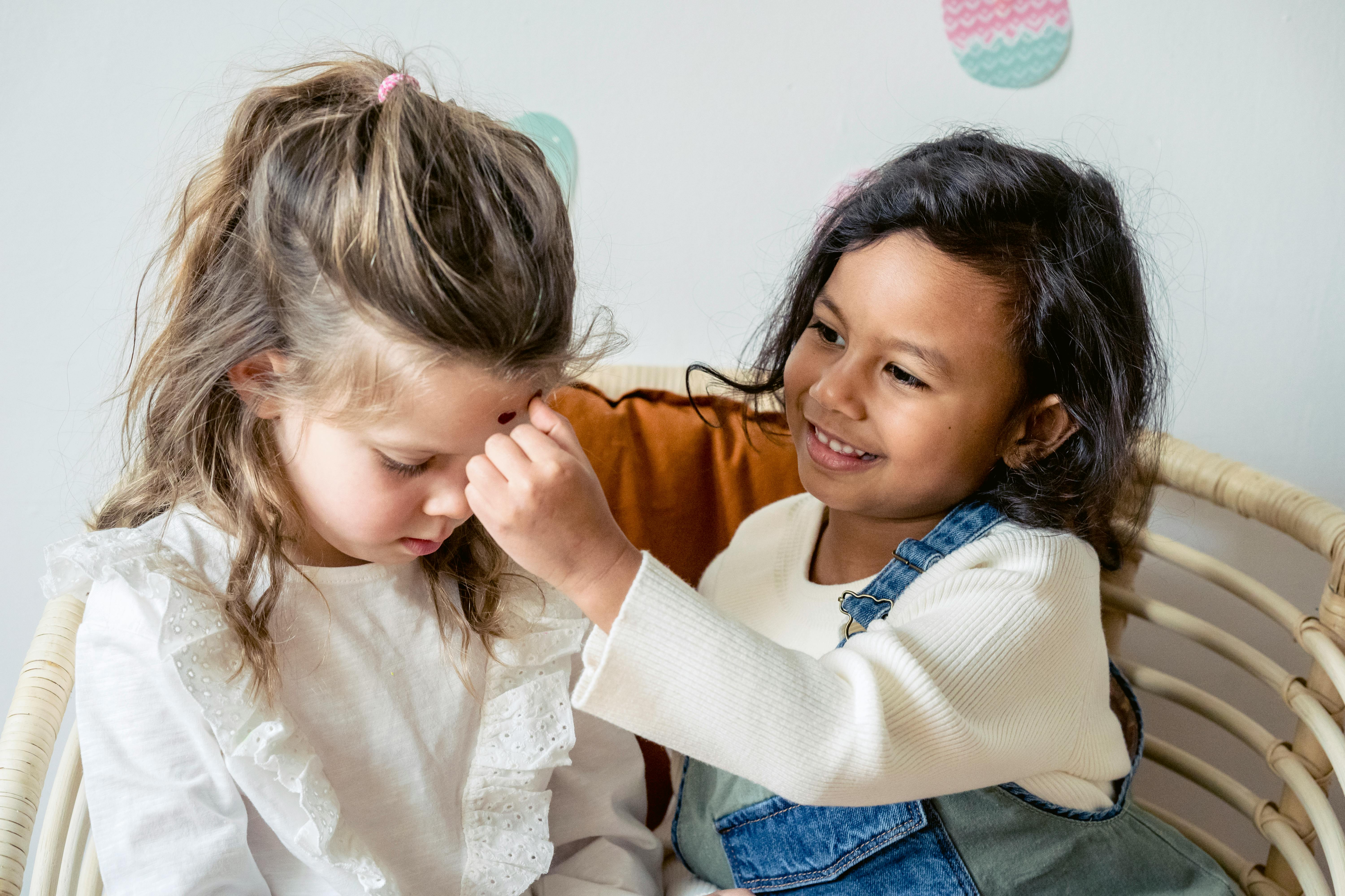 hispanic girl playing with friend on sofa