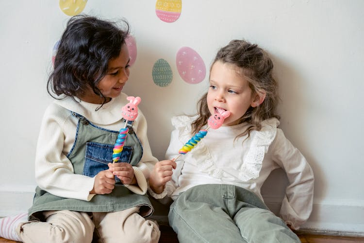 Little Diverse Girls Eating Candies Sitting On Floor