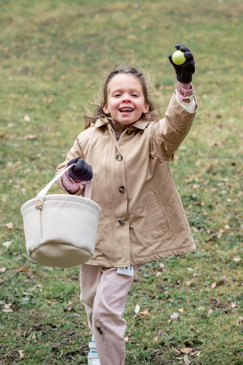 Free Little girl showing green plastic egg in countryside Stock Photo