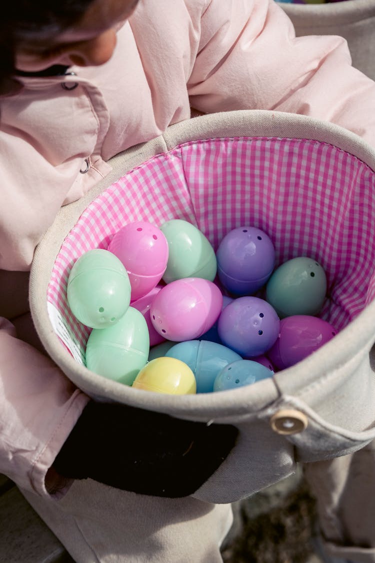 Crop Child With Wicker Basket Full Of Easter Eggs