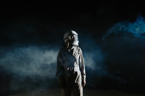 Free Person in Gray Space Suit Standing with Smoke on Background Stock Photo