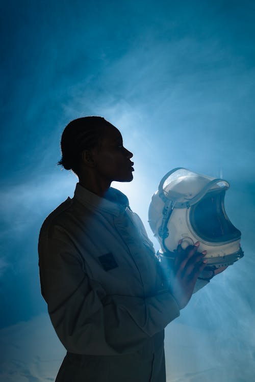 Woman Wearing Space Suit and Holding Helmet