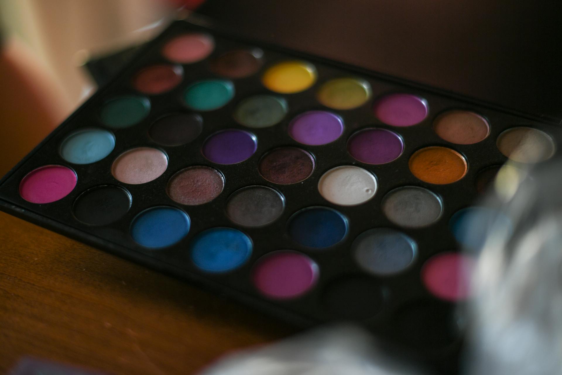 Close-up of a colorful eyeshadow palette with a variety of vibrant shades.