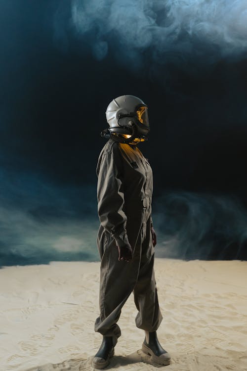 Person in Space Suit with White Helmet Standing in Outer Space