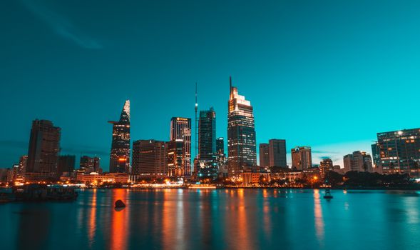 Stunning night cityscape featuring a brightly illuminated skyline reflected on the water.