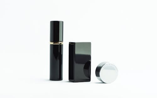 Close-Up Shot of a Black Perfume on a White Surface