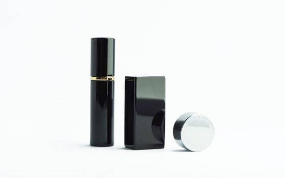 Minimalist shot of sleek black perfume bottles on a white surface.