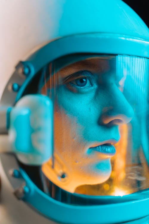 Woman Wearing White Space Helmet with Blue and Orange Light Reflections