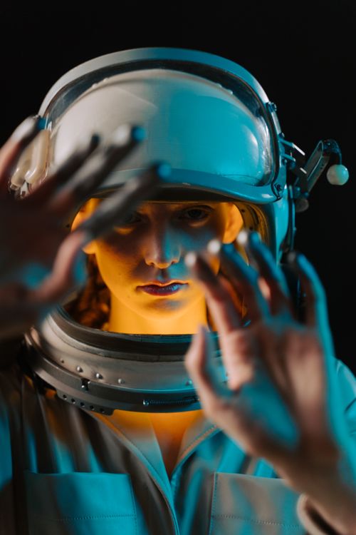 Free A striking portrait of a female astronaut in a spacesuit with neon lighting. Stock Photo