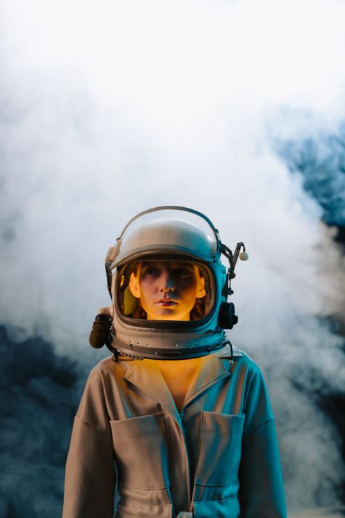 Free Astronaut woman in a spacesuit with smoke in a sci-fi scene, modern exploration. Stock Photo