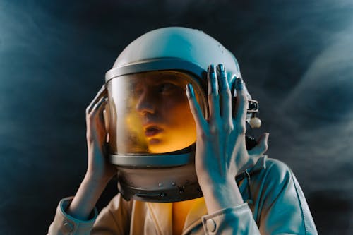 Woman in Astronaut Suit Touching Helmet 