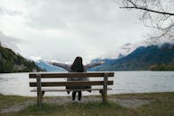 Woman Sitting on Bench by Lake