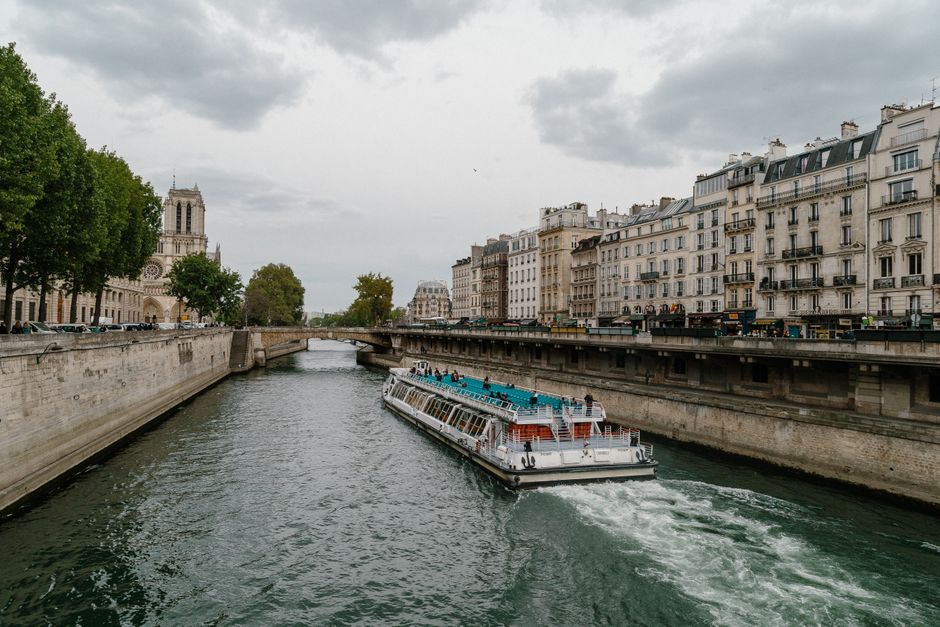 A Bateaux Mouches boat cruising on the Seine River in Paris at sunset