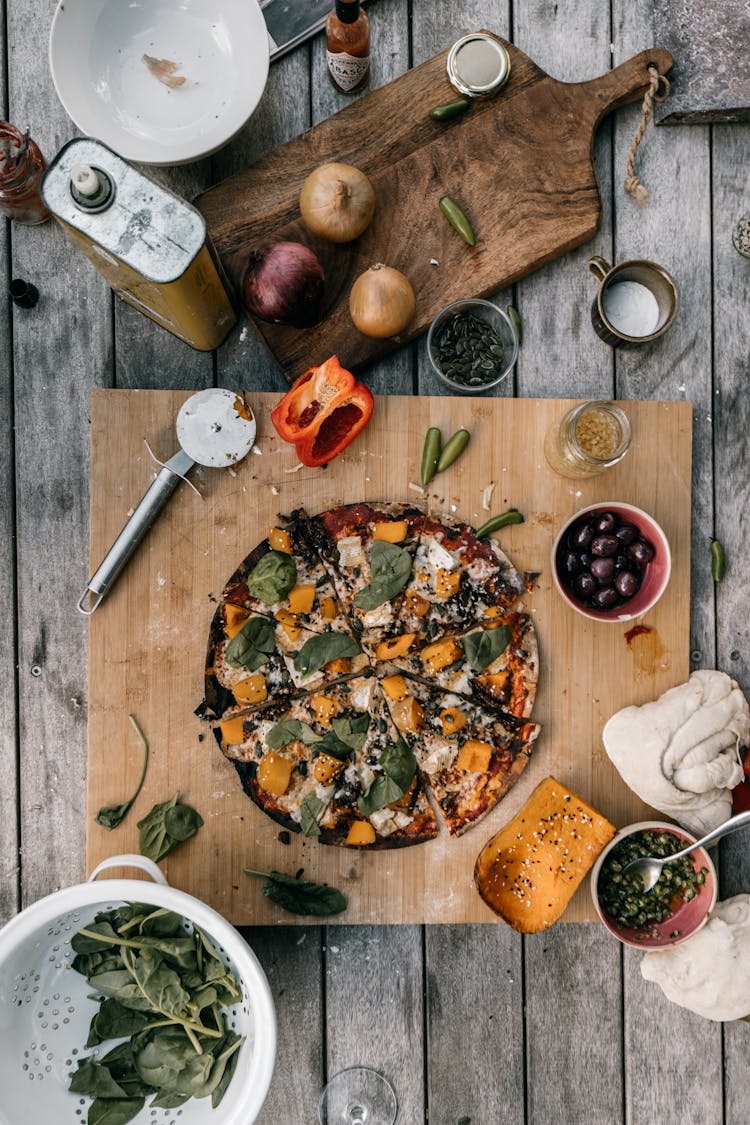 A Flatlay Of A Pizza And Some Raw Ingredients