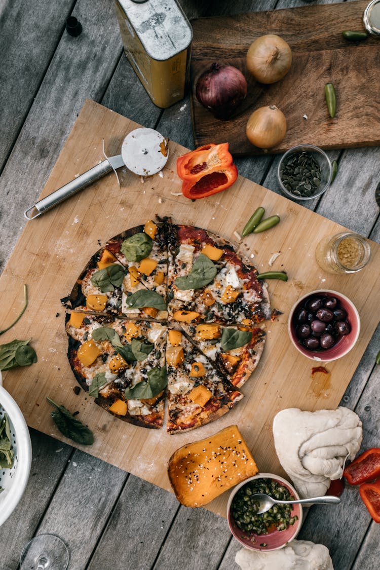 A Flatlay Of A Pizza And Some Raw Ingredients