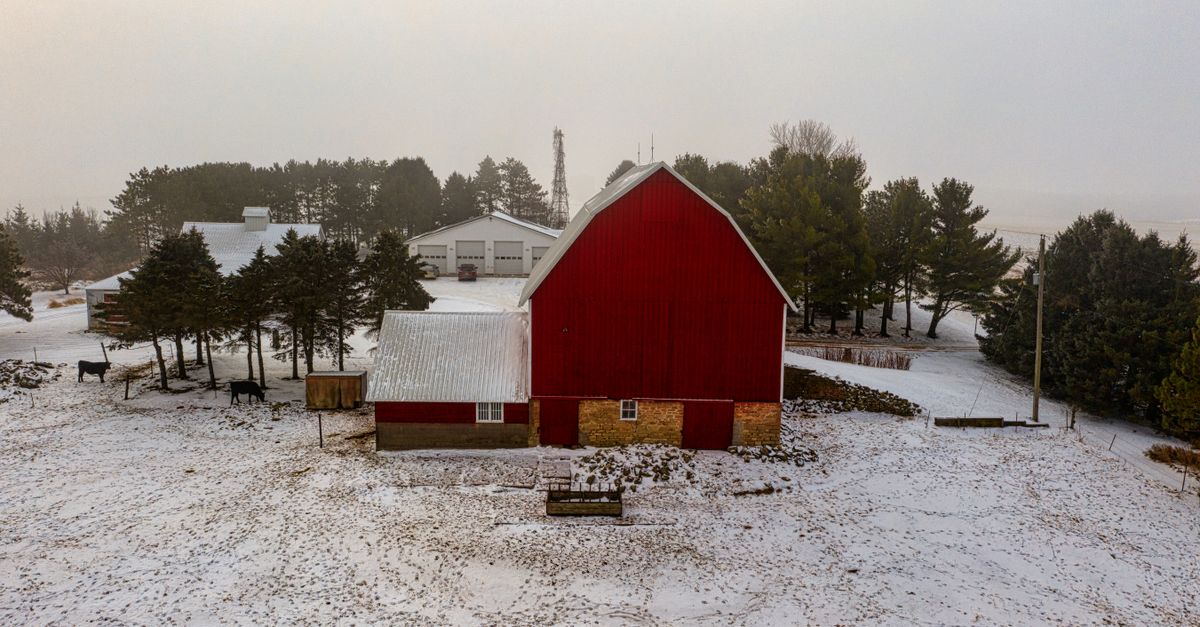 Aerial view of a red barn amidst a snowy rural landscape in Lake City, Minnesota.