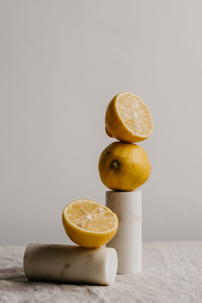 Halved lemons stacked on a marble plinth