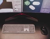 Close-Up Shot of Wireless Keyboard and Mouse near Computer Monitor