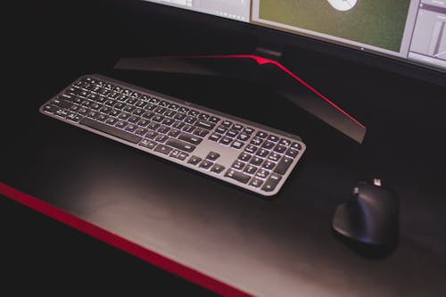 Black and Silver Computer Keyboard on Black Table Top