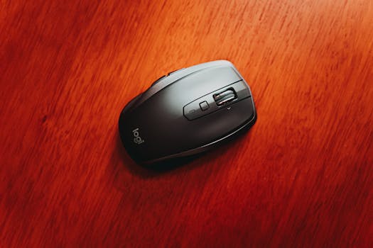 Close-up of a wireless computer mouse on a polished wooden surface. Ideal for tech-related content.