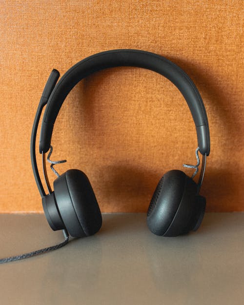 Modern headphones placed near wall at home