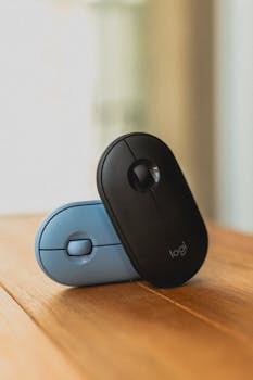Stylish black and blue wireless computer mice placed on a wooden table, highlighting modern technology.