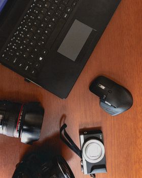 From above of modern netbook placed near computer mouse and photo camera with lens for online work