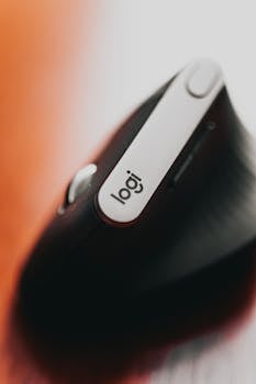 From above of modern wireless computer mouse with creative logo on side placed on table