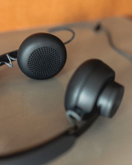 Free From above of contemporary black headphones with wire placed on table at workplace Stock Photo