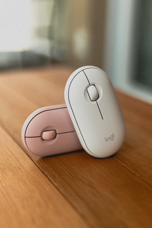 Modern computer mice placed on wooden table