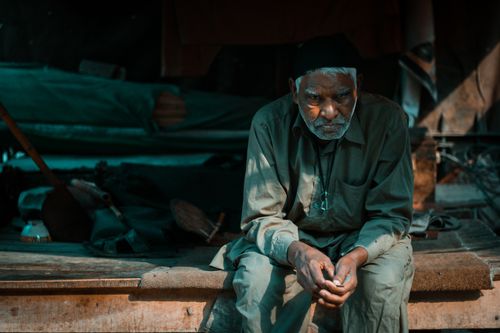 Free A contemplative senior man sits thoughtfully outdoors in Lahore, Pakistan. Stock Photo