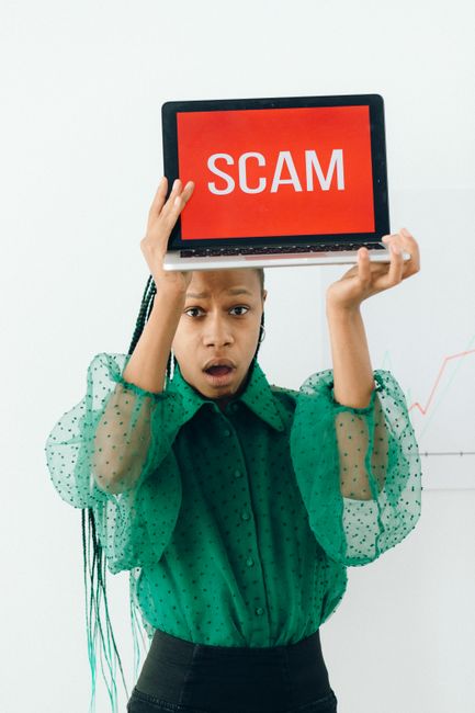 5 Essential Strategies To Prevent Phishing &Amp; Insider Threats 4 - 5 Essential Strategies,Prevent Phishing,Cybersecurity Awareness Training For Small Energy Businesses - - Bonelli Systems African American Woman Holding Laptop Displaying A Scam Alert, Highlighting Online Fraud.