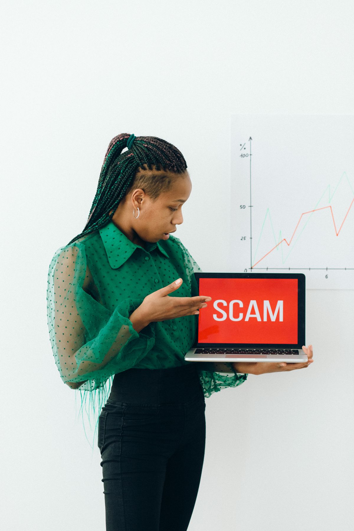Woman pointing at a laptop showing a scam warning while checking a fake Salesforce job listing