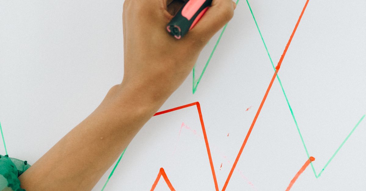 Photo by Nataliya Vaitkevich Person writing on sticky note placed on business chart, capturing financial strategy concept.