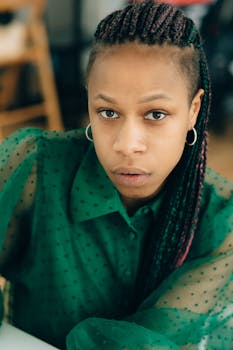 Portrait of a woman in a green sheer blouse, exuding confidence and style.