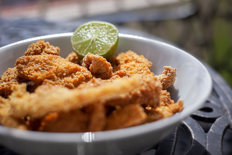 Breaded Fried Food In A Bowl With A Citrus Fruit