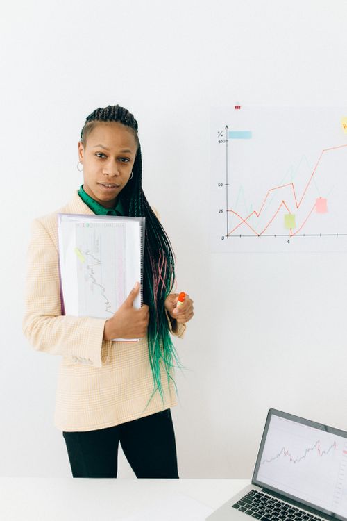 Free Confident analyst presenting financial data and growth charts in a modern office setting. Stock Photo