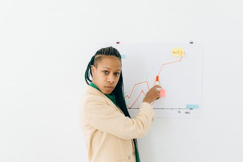 Free Confident woman explains financial data and growth strategy in a presentation. Stock Photo