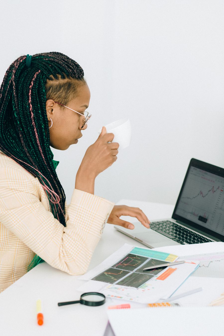 African data analyst reviewing stock charts and visualizations on a laptop