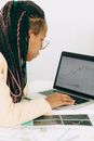 Woman in a Beige Jacket Analyzing the Graph on her Laptop
