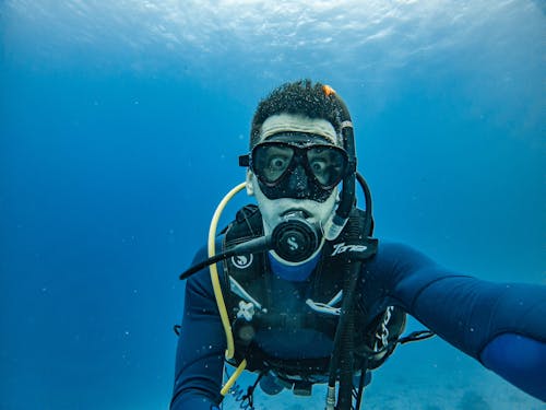 Man Wearing Goggles and Oxygen while Underwater