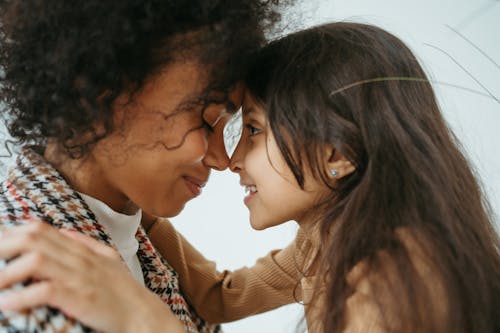 Free Child Hugging a Woman Face to Face Stock Photo