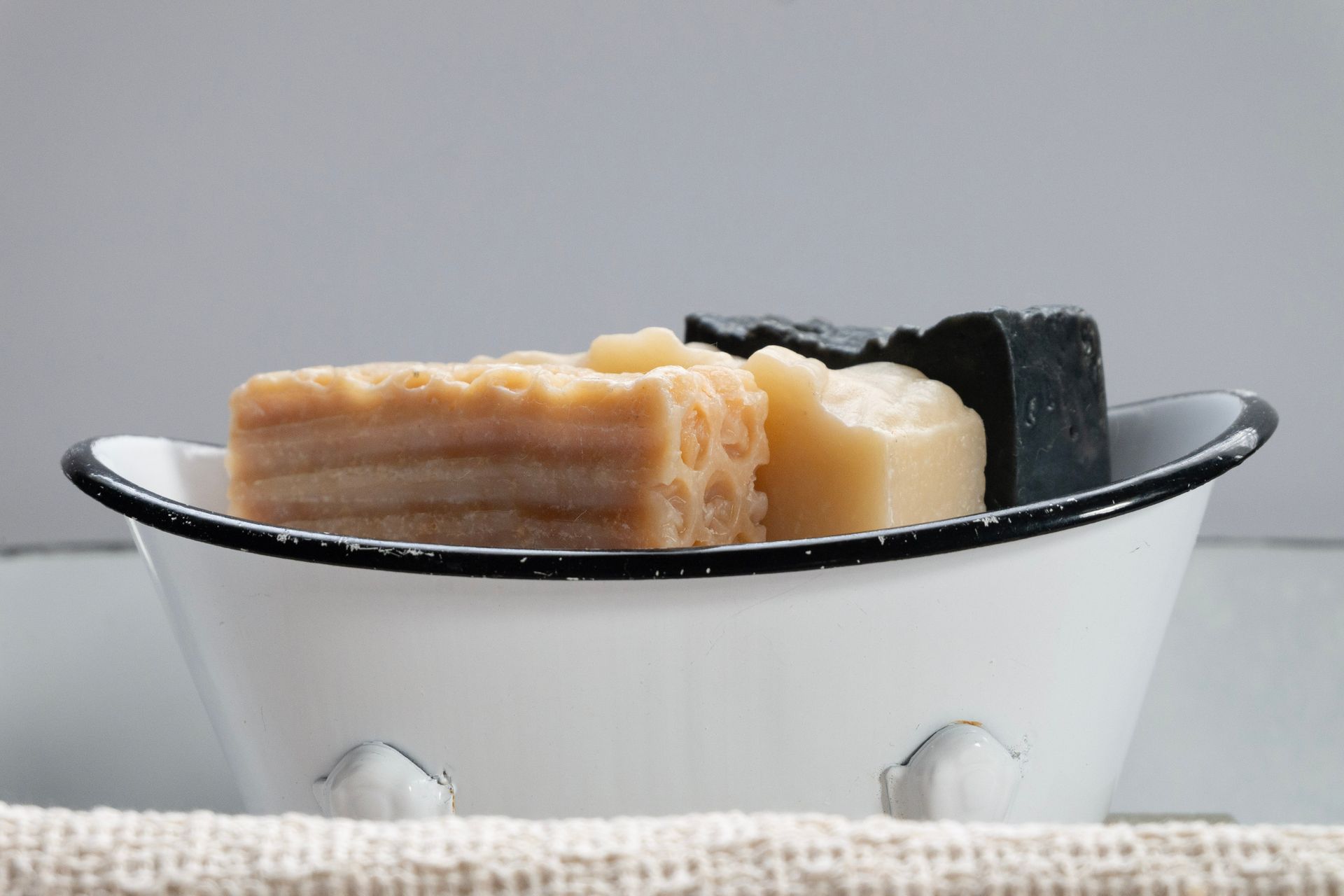 Close-up of assorted handmade soaps in a vintage soap dish.
